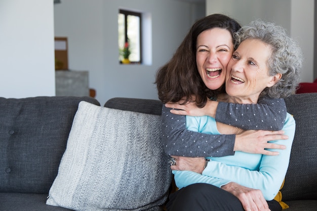 Retrato de feliz mediados de mujer adulta abrazando a su madre senior