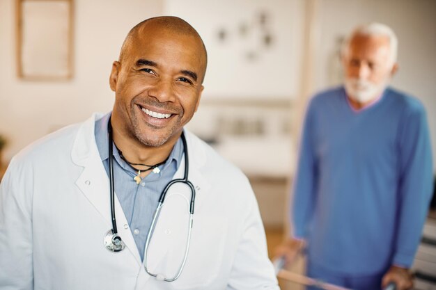 Retrato de feliz médico afroamericano en el hogar de ancianos