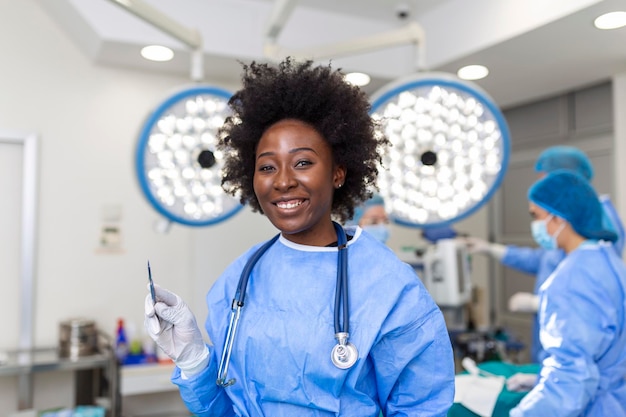 Retrato de feliz mujer afroamericana cirujana de pie en el quirófano lista para trabajar en un paciente Trabajadora médica en uniforme quirúrgico en el quirófano
