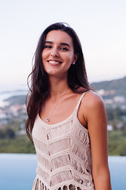 Foto gratuita retrato de feliz mujer romántica tranquila caucásica en look casual con el pelo largo con aretes y collar sobre fondo increíble vista hermosa en montañas verdes