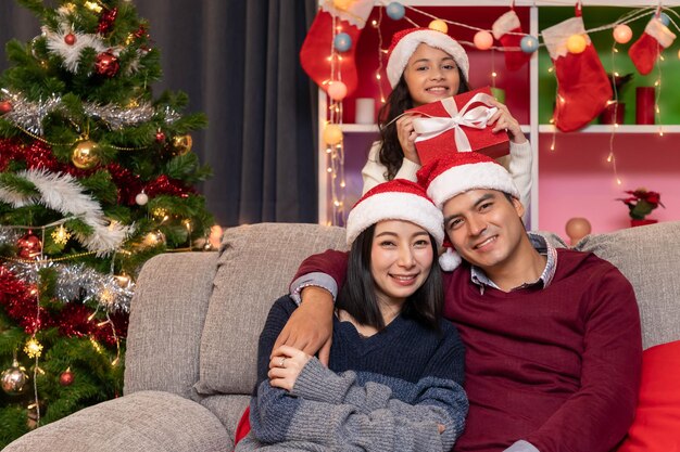 Retrato de feliz padre de familia madre e hija celebran la Navidad en la temporada de vacaciones de la sala de estar