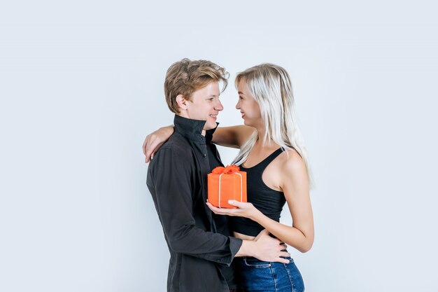 Retrato de feliz pareja joven amor juntos sorpresa con caja de regalo