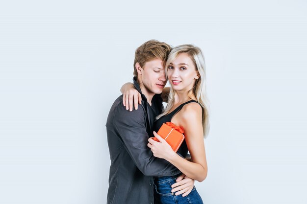 Retrato de feliz pareja joven amor juntos sorpresa con caja de regalo