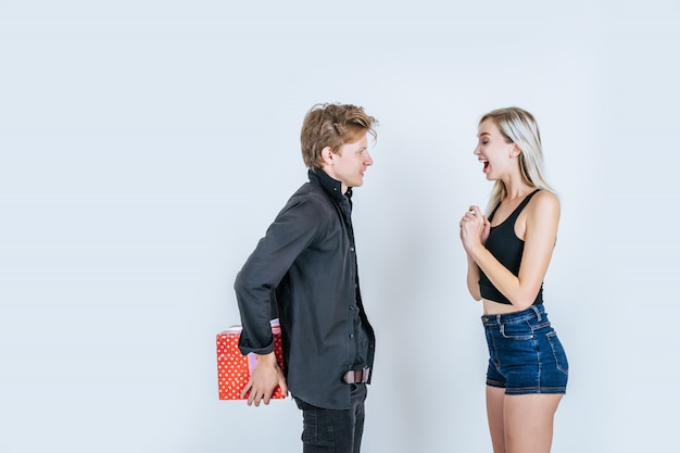 Retrato de feliz pareja joven amor juntos sorpresa con caja de regalo