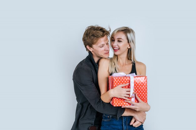 Retrato de feliz pareja joven amor juntos sorpresa con caja de regalo