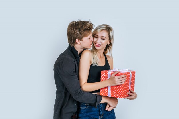 Retrato de feliz pareja joven amor juntos sorpresa con caja de regalo
