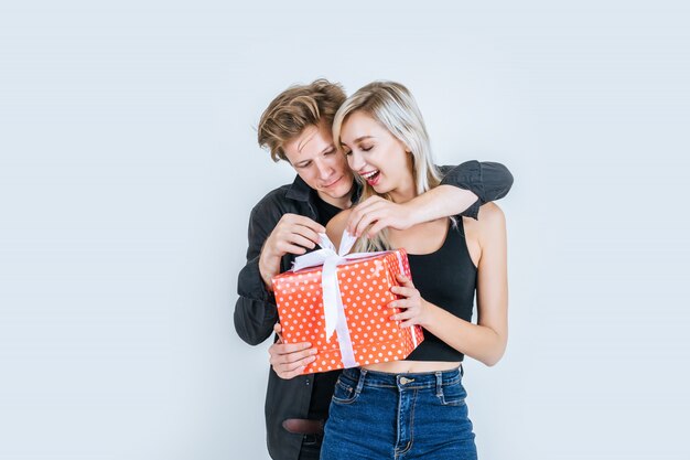 Retrato de feliz pareja joven amor juntos sorpresa con caja de regalo