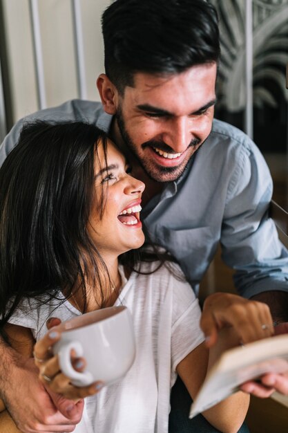 Retrato de la feliz pareja joven mirando el libro