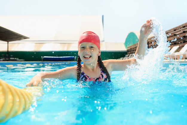 El retrato de feliz sonriente hermosa jovencita en la piscina