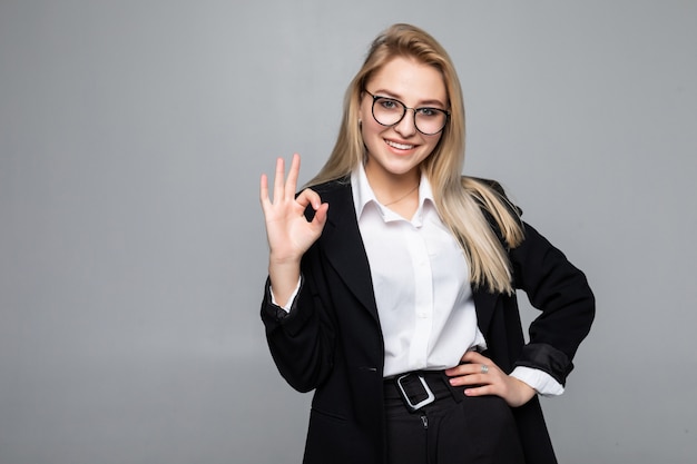 Retrato de feliz sonriente joven empresaria alegre mostrando signo bien aislado