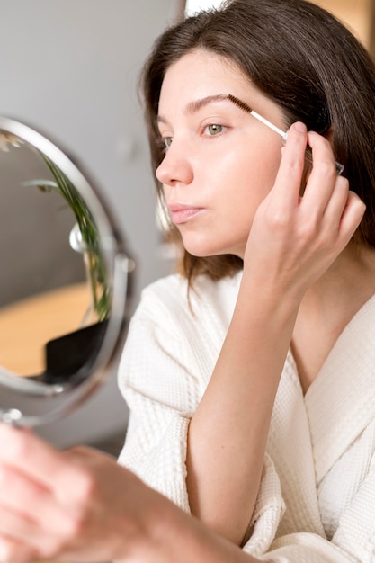 Foto gratuita retrato femenino haciendo maquillaje para cejas