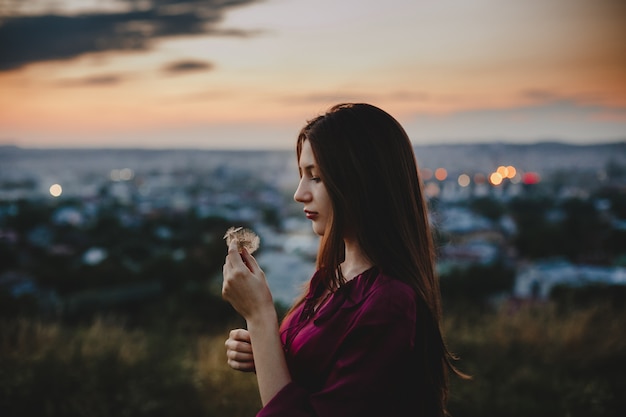 Foto gratuita retrato femenino naturaleza. linda mujer juega con soporte de diente de león