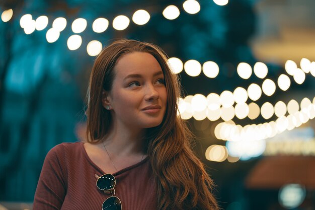 Retrato femenino romántico con luces de la ciudad