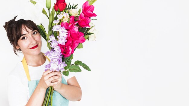 Retrato de una florista mujer sonriente con ramo de flores