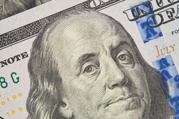 Retrato de Franklin en un billete de cien dólares Primer plano de billetes de cien dólares estadounidenses enfoque selectivo Concepto de finanzas empresariales noticias de negocios maqueta de banner de pantalla de bienvenida