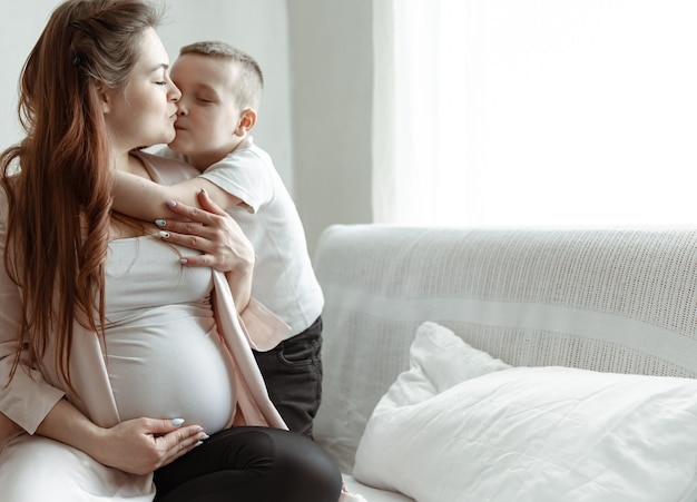 Retrato de una futura madre con su pequeño hijo en un espacio de copia de abrazo.