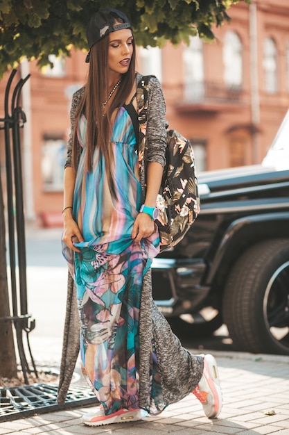 Foto gratuita retrato de glamour hermosa morena adolescente modelo en ropa hipster de verano y bolso. chica posando en la calle. mujer con gorra