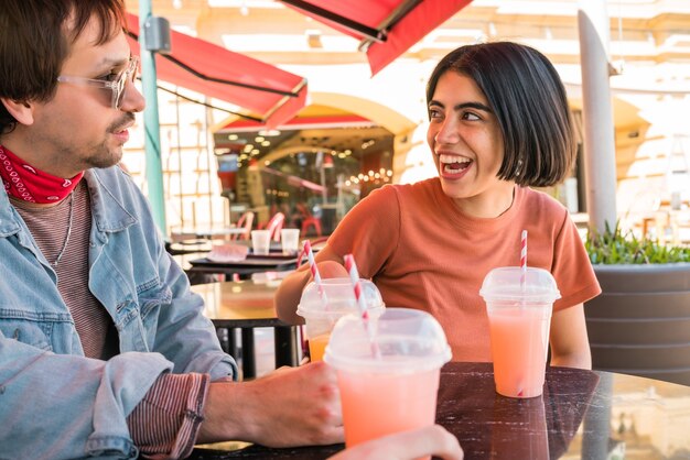 Retrato de un grupo de amigos que se divierten juntos y disfrutan de un buen rato mientras beben jugo de fruta fresca en el café