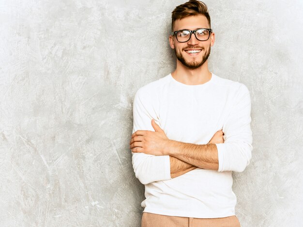 Retrato de guapo modelo de empresario hipster sonriente vistiendo ropa casual de verano blanco.