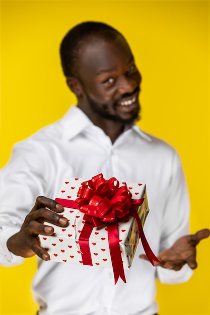 Retrato de guapo negro con foco en un regalo