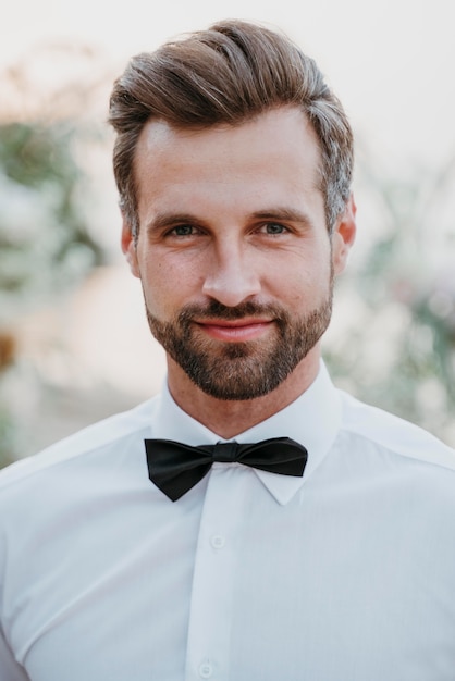 Retrato de guapo novio en su boda en la playa