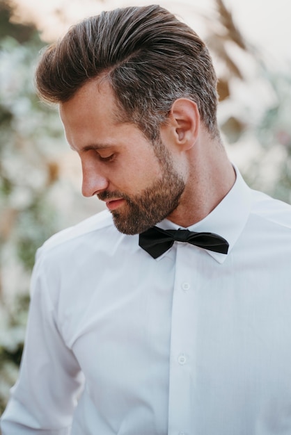 Retrato de guapo novio en su boda en la playa