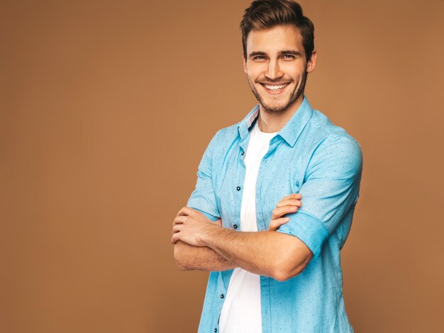 Retrato de guapo sonriente elegante joven modelo vestido con ropa de jeans. Hombre de moda. Posando