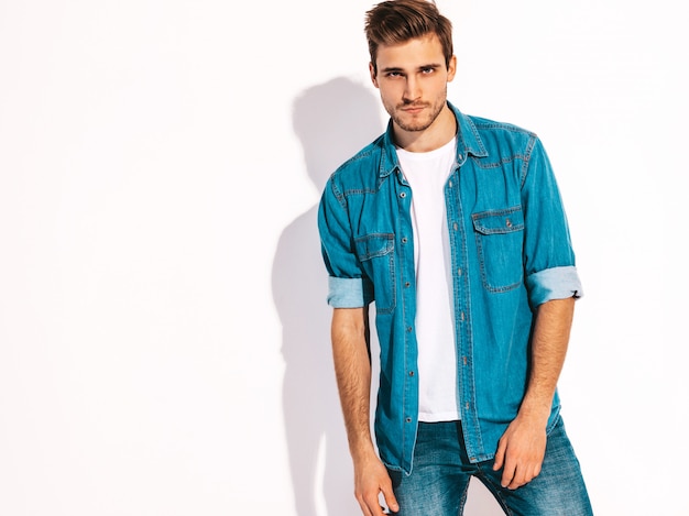 Foto gratuita retrato de guapo sonriente elegante joven modelo vestido con ropa de jeans. hombre de moda