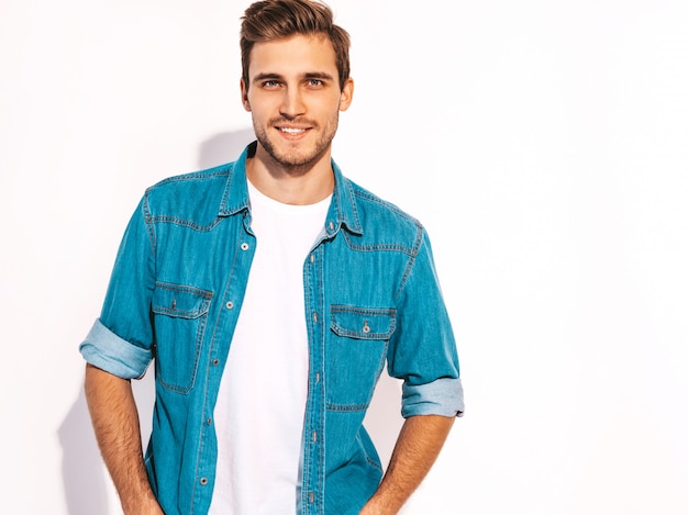 Foto gratuita retrato de guapo sonriente elegante joven modelo vestido con ropa de jeans. hombre de moda