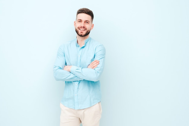 Retrato de guapo sonriente joven vistiendo pantalones y camisa casual