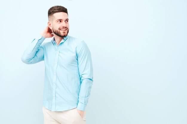 Retrato de guapo sonriente joven vistiendo pantalones y camisa casual