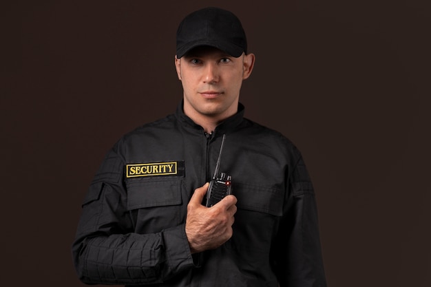 Retrato de guardia de seguridad masculino con estación de radio