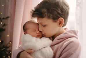 Foto gratuita retrato de un hermano que cuida a su hermano recién nacido