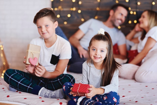 Retrato de hermanos felices con regalos de Navidad