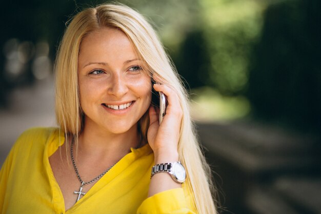 Retrato de la hermosa chica rubia hablando por teléfono