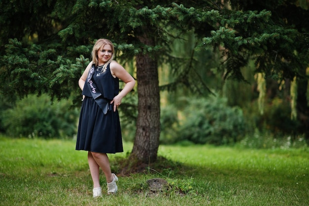 Retrato de una hermosa chica vestida de negro en una despedida de soltera posada en el parque