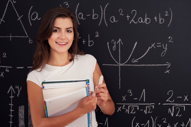 Retrato de hermosa estudiante con tiza y cuaderno de espiral