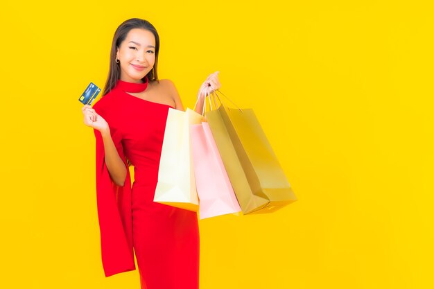 Retrato hermosa joven asiática con bolsa de compras y tarjeta de crédito