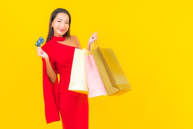 Retrato hermosa joven asiática con bolsa de compras y tarjeta de crédito