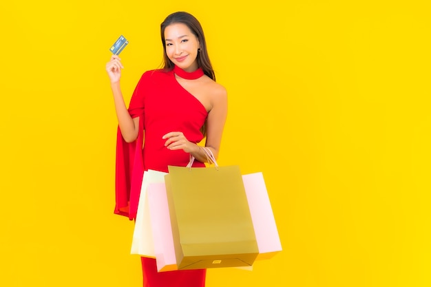 Retrato hermosa joven asiática con bolsa de compras y tarjeta de crédito