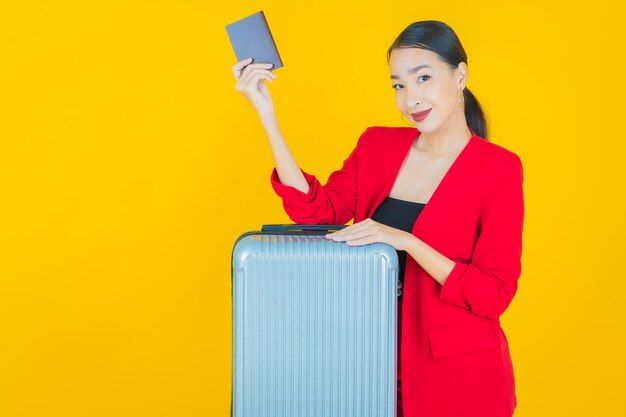 Retrato hermosa joven asiática con bolsa de equipaje y pasaporte listo para viajar