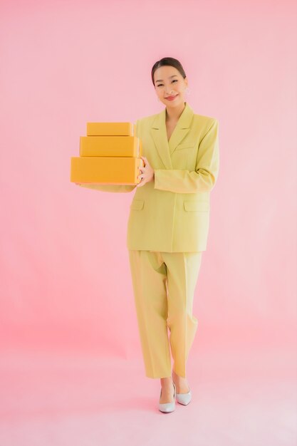 Retrato hermosa joven asiática con caja de paquetería en color