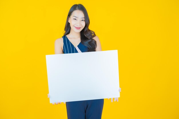 Retrato hermosa joven asiática con cartelera blanca vacía en