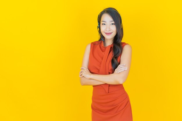 Retrato hermosa joven asiática con centro de servicio de atención al cliente de call center en amarillo