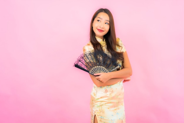 Retrato hermosa joven asiática con concepto de año nuevo chino y ventilador en la pared de color