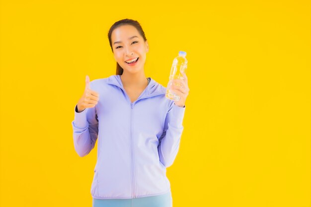 Retrato hermosa joven asiática deporte mujer lista para hacer ejercicio en amarillo