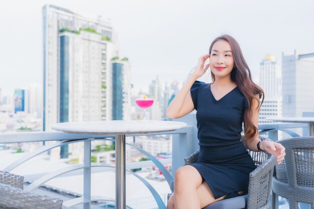 Retrato hermosa joven asiática disfruta con cócteles beber vidrio