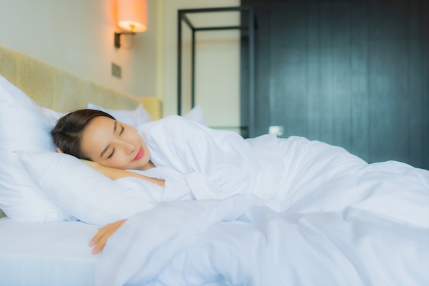 Retrato hermosa joven asiática dormir en la cama con almohada y manta