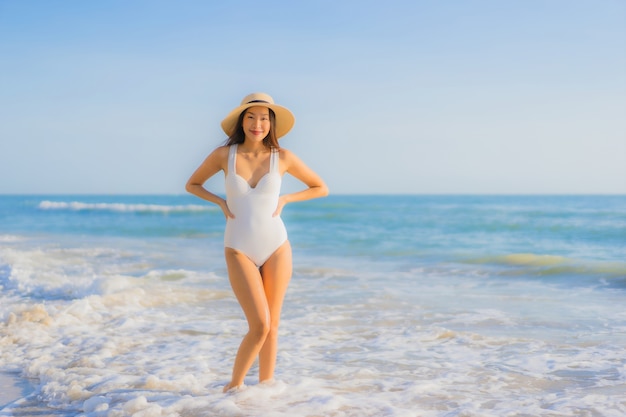 Retrato hermosa joven asiática feliz sonrisa alrededor del mar océano playa