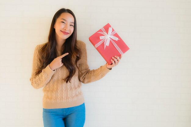 Retrato hermosa joven asiática feliz sonrisa con caja de regalo